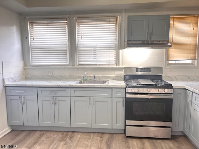 a kitchen with granite countertop white cabinets and a stove