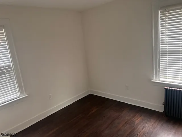 a view of a small space with wooden floor and a window