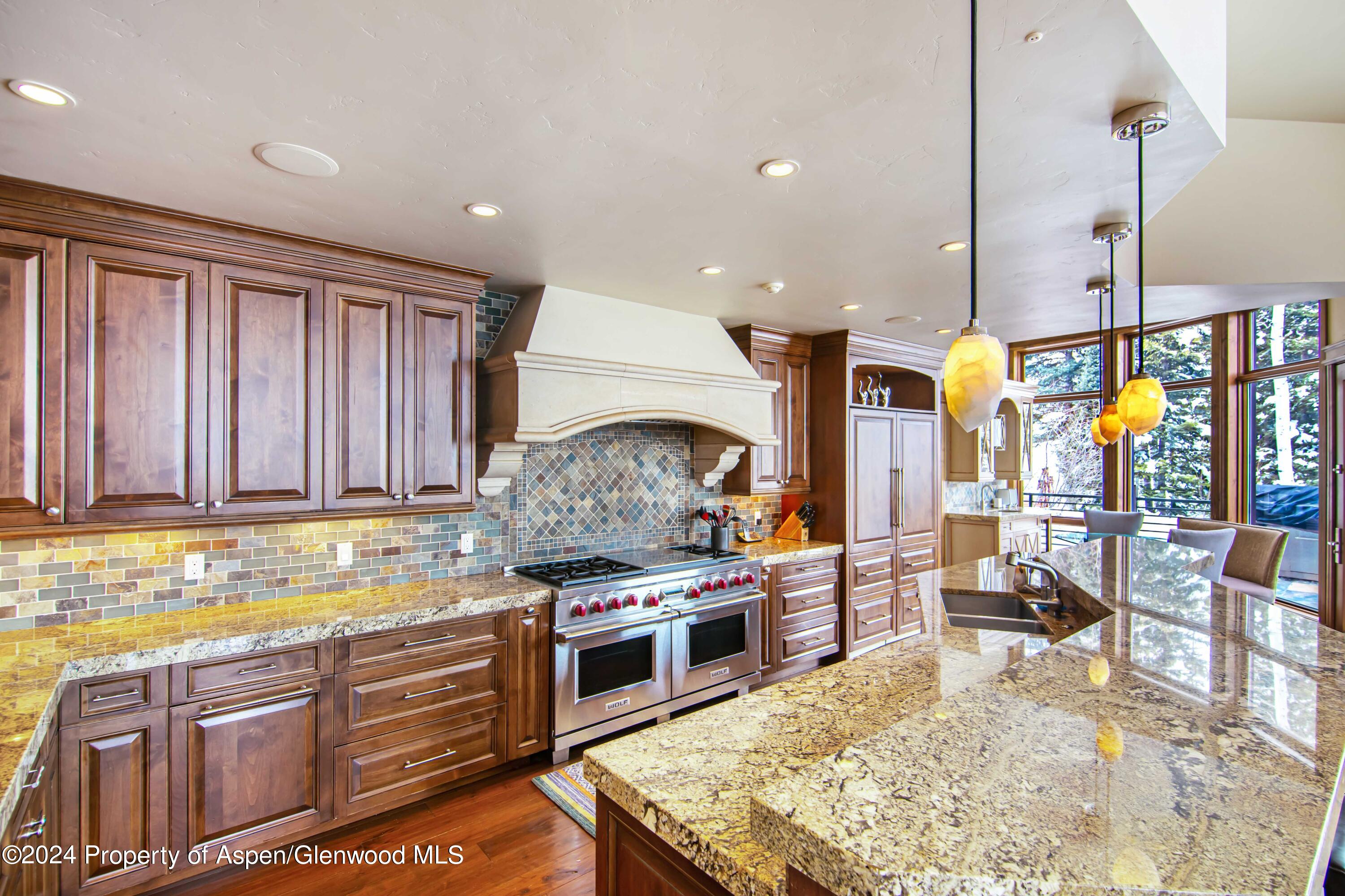 1457 Wood Road Snowmass Village, CO 81615 - Photo 17 of 70 a kitchen with stainless steel appliances granite countertop a stove a sink and a microwave