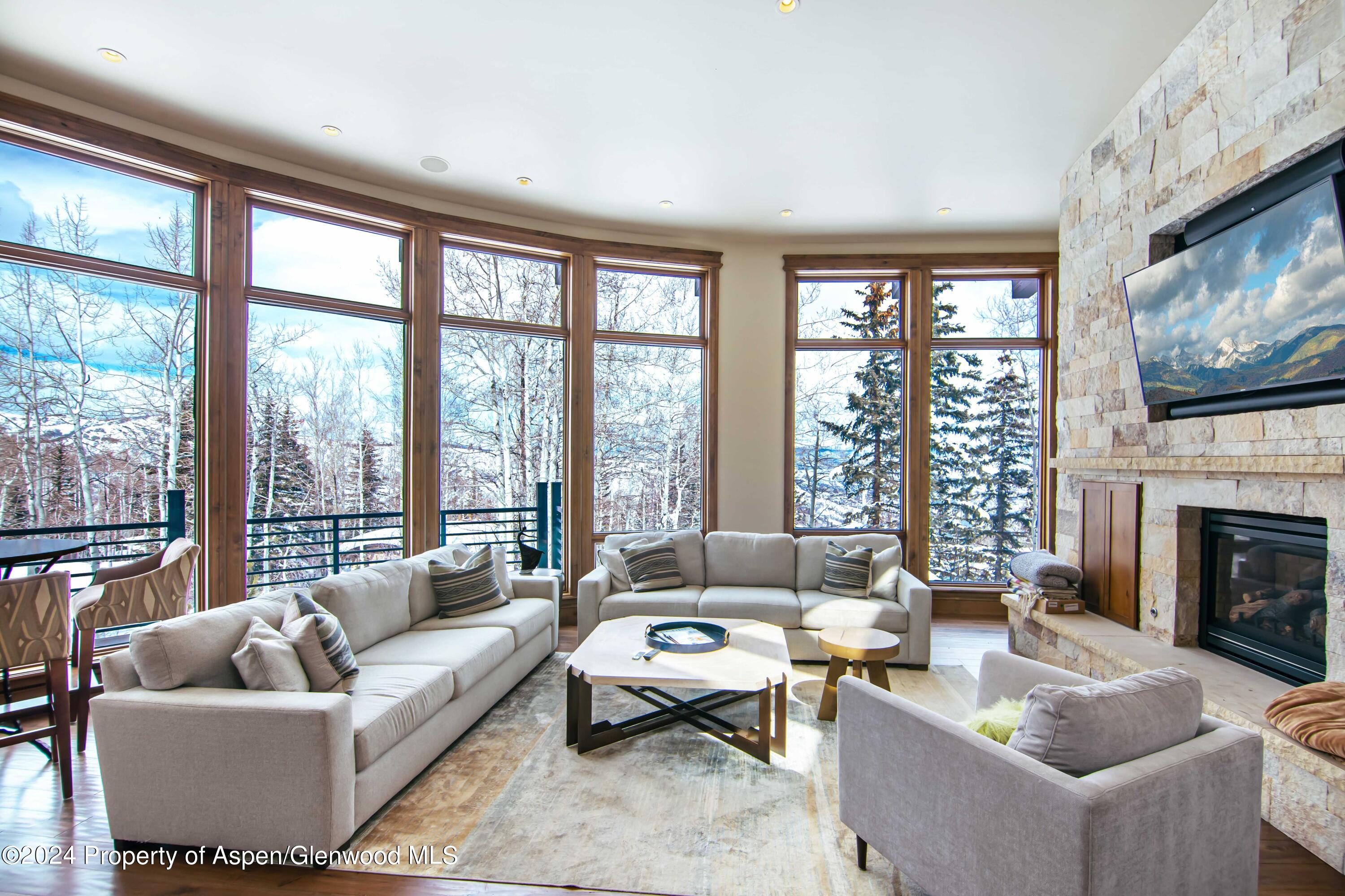 1457 Wood Road Snowmass Village, CO 81615 - Photo 2 of 70 a living room with furniture large window and a fireplace