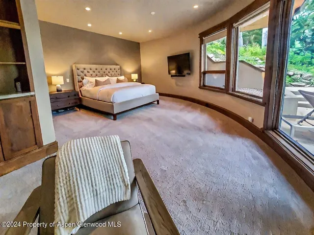 a bedroom with a bed couch and a large window