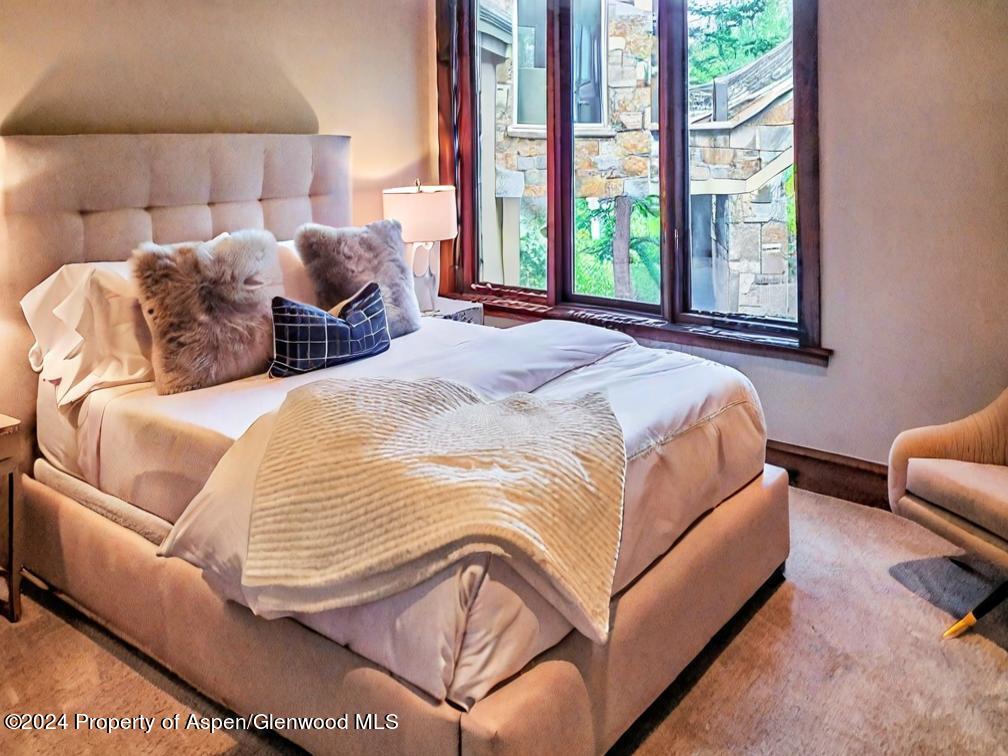 1457 Wood Road Snowmass Village, CO 81615 - Photo 37 of 70 a bedroom with a bed couch and a large window