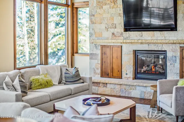 a dining room with furniture a floor to ceiling window and wooden floor