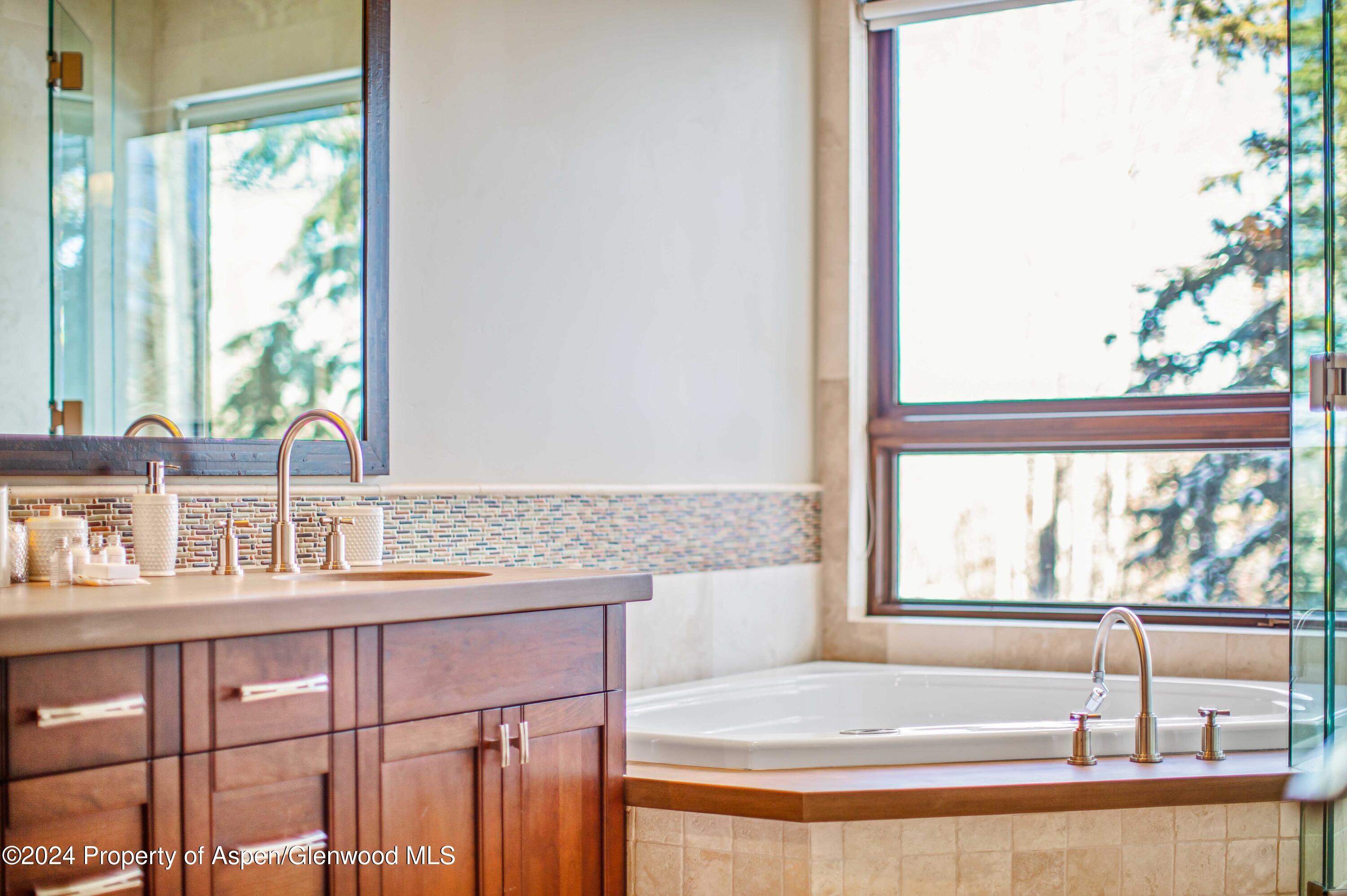 1457 Wood Road Snowmass Village, CO 81615 - Photo 62 of 70 a bathroom with a granite countertop sink and a large mirror next to a yard