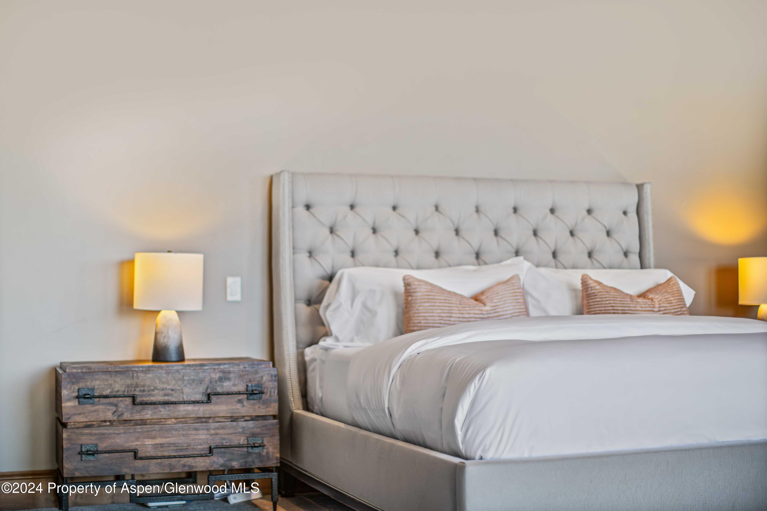 1457 Wood Road Snowmass Village, CO 81615 - Photo 67 of 70 a bedroom with a bed and lamp