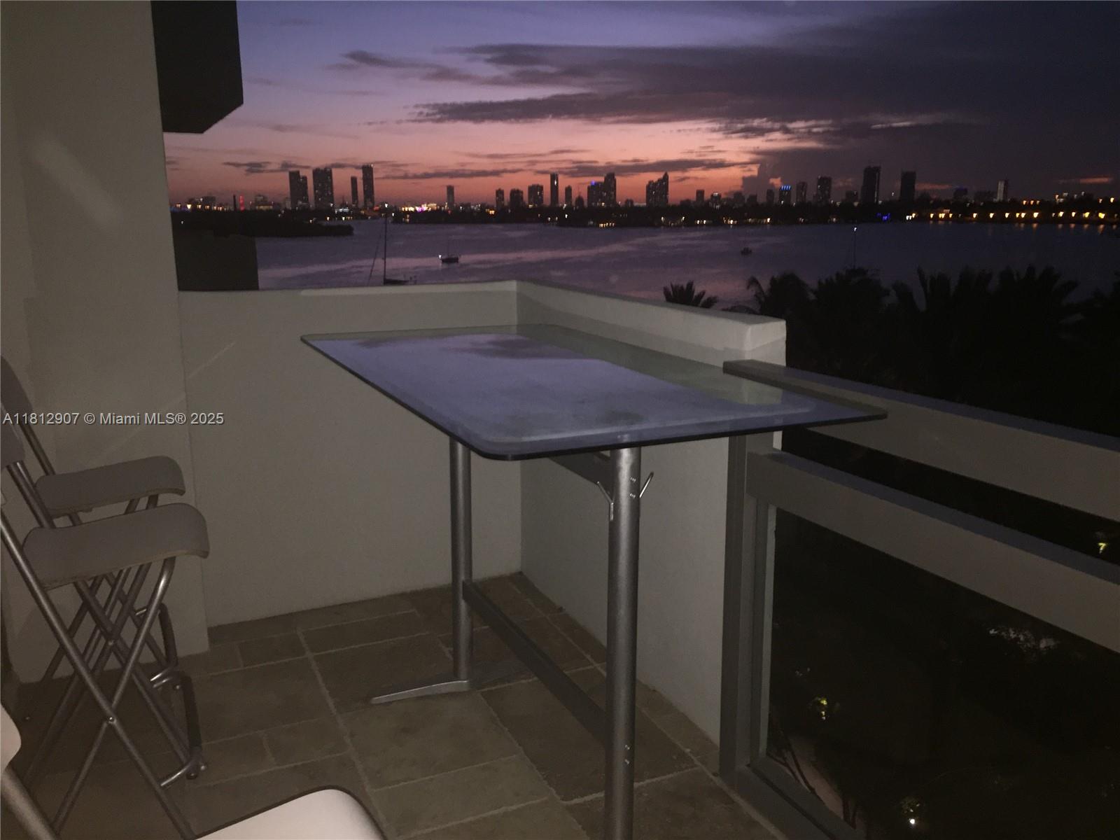 1500 Bay Road, Unit 644S Miami Beach, FL 33139 - Photo 12 of 24 a terrace with a table and chairs