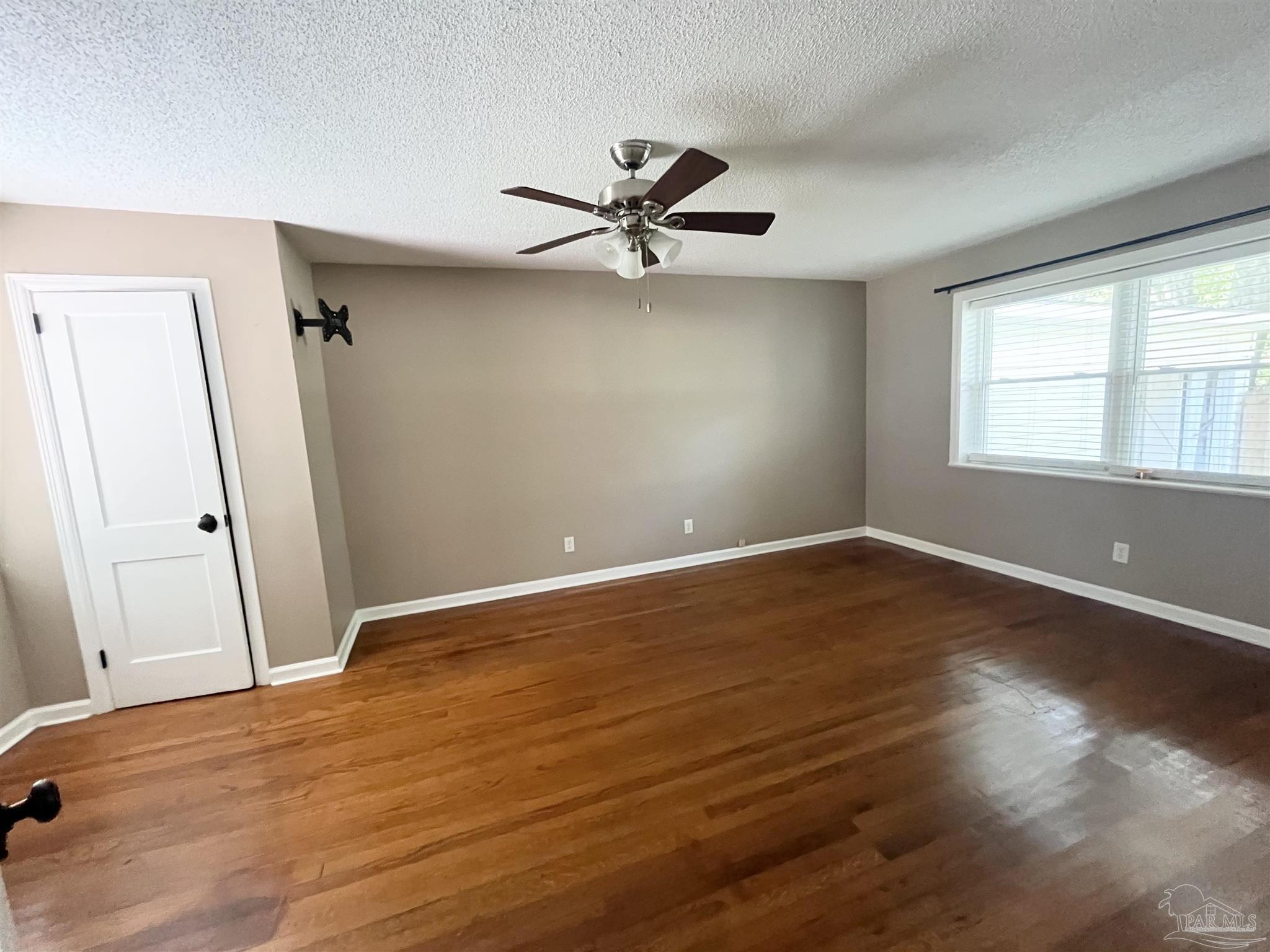 326 East Horner Street Atmore, AL 36502 - Photo 11 of 26 an empty room with wooden floor and windows