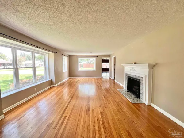 a view of empty room with wooden floor and fireplace
