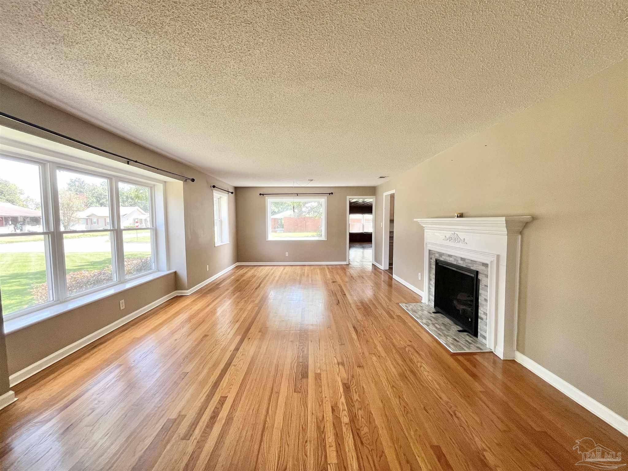 326 East Horner Street Atmore, AL 36502 - Photo 3 of 26 a view of empty room with wooden floor and fireplace