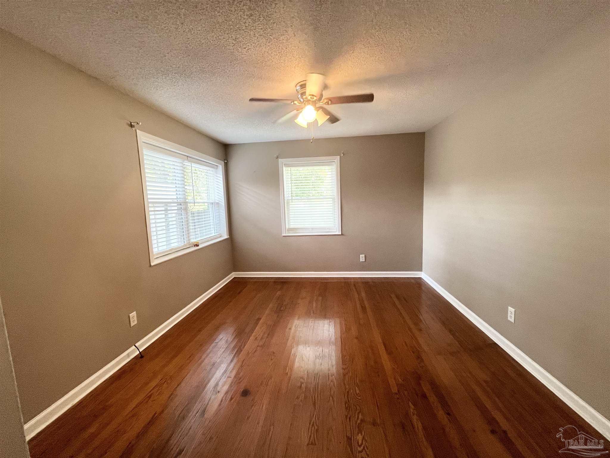326 East Horner Street Atmore, AL 36502 - Photo 5 of 26 wooden floor in an empty room with a window