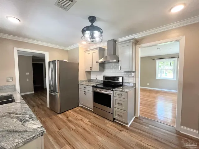 a kitchen with stainless steel appliances granite countertop a stove a refrigerator and a sink