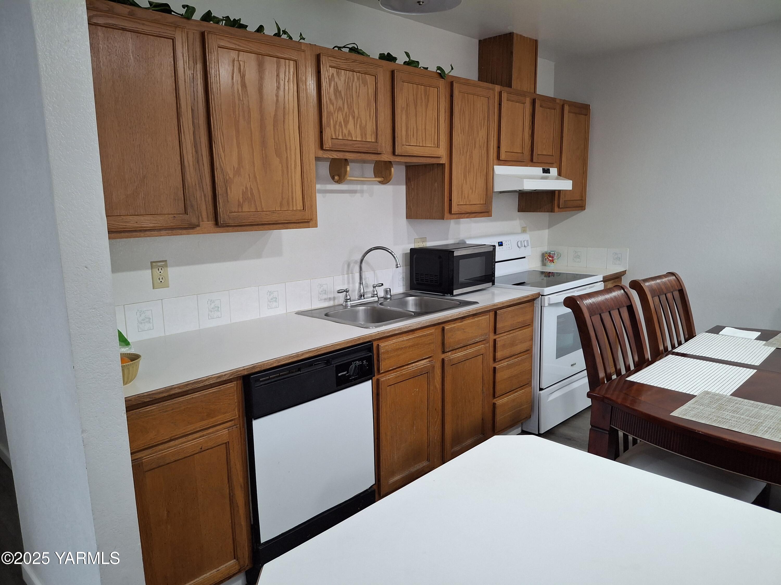 866 Ismo Loop Sunnyside, WA 98944 - Photo 6 of 17 a kitchen with stainless steel appliances a sink a stove a refrigerator cabinets and a counter top space