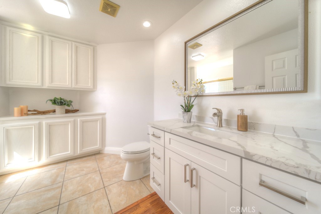 32230 Corte Chatada Temecula, CA 92592 - Photo 35 of 53 a bathroom with a granite countertop sink a toilet and a mirror