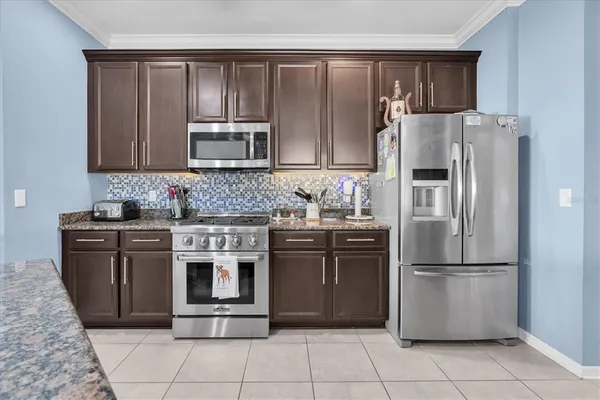 a kitchen with stainless steel appliances granite countertop a refrigerator stove and microwave