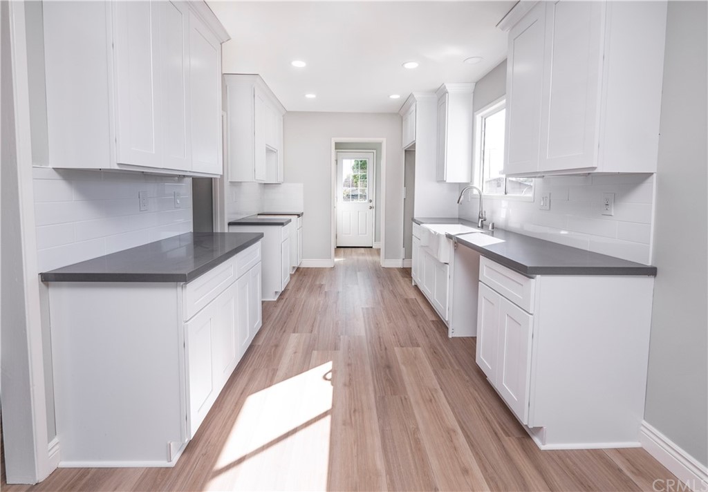 150 East Gladstone Street San Dimas, CA 91773 - Photo 12 of 37 a kitchen with granite countertop white cabinets and white appliances