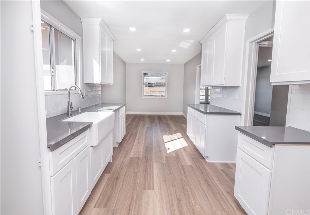 150 East Gladstone Street San Dimas, CA 91773 - Photo 15 of 37 a kitchen with kitchen island wooden floors appliances and sink