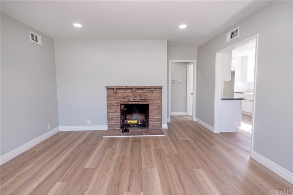 150 East Gladstone Street San Dimas, CA 91773 - Photo 9 of 37 a view of an empty room with wooden floor fire place and a window