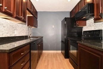 30 Juniper Road, Unit 34 North Attleboro, MA 02760 - Photo 3 of 8 a kitchen with stainless steel appliances granite countertop a sink stove and refrigerator