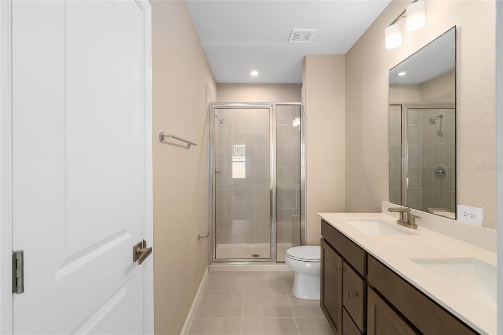 1183 Turtle Is Road Lady Lake, FL 32159 - Photo 21 of 39 a bathroom with a double vanity sink toilet mirror and shower