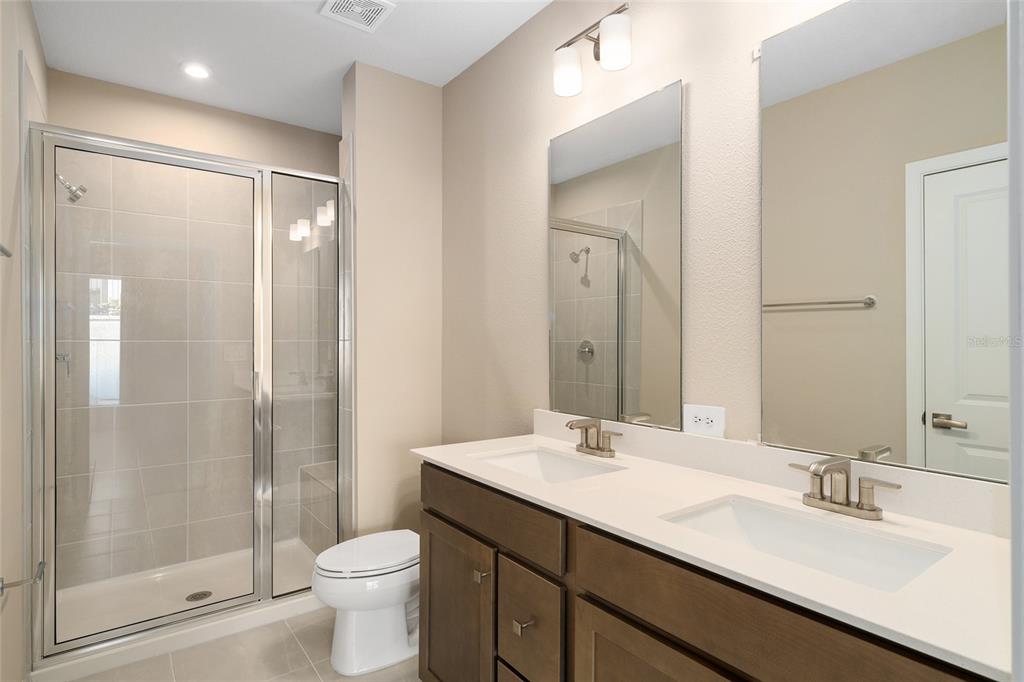 1183 Turtle Is Road Lady Lake, FL 32159 - Photo 22 of 39 a bathroom with a double vanity sink toilet and shower