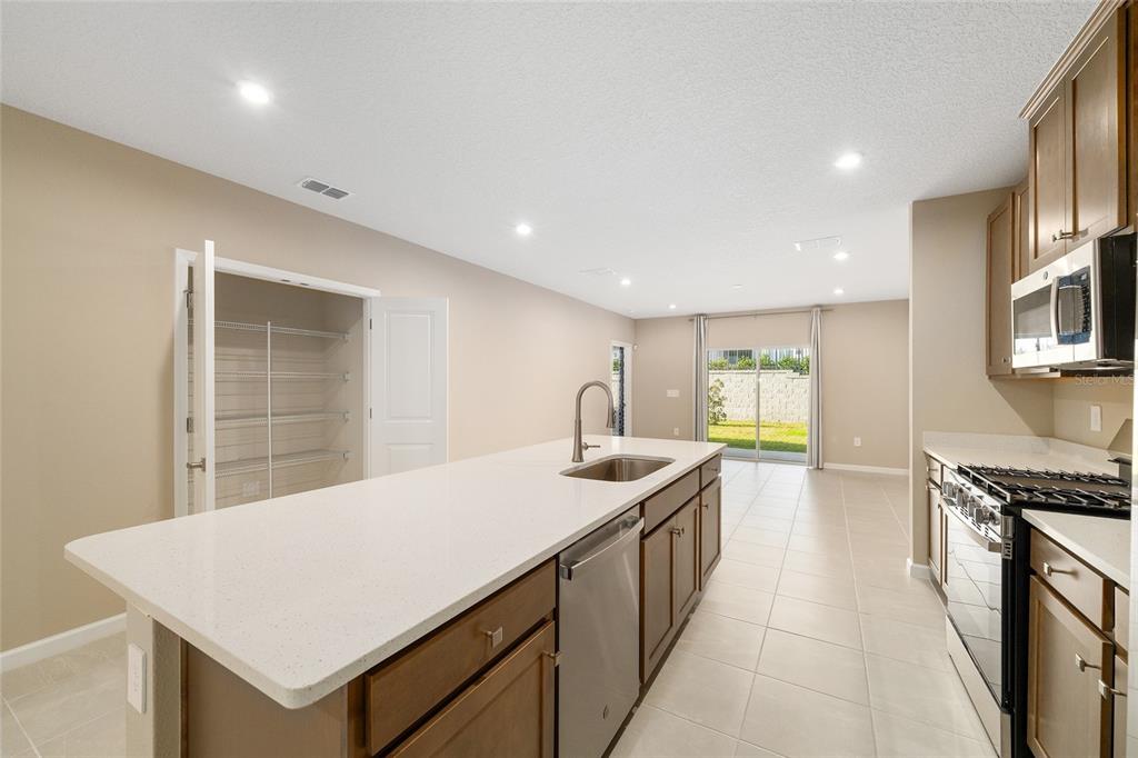 1183 Turtle Is Road Lady Lake, FL 32159 - Photo 35 of 39 a large kitchen with stainless steel appliances a sink a counter space and a refrigerator