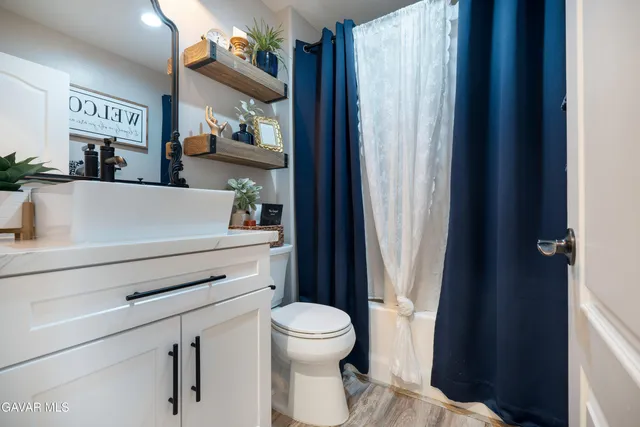 a bathroom with a toilet a sink and a large mirror