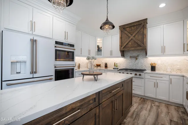 a kitchen with granite countertop a sink stainless steel appliances and cabinets