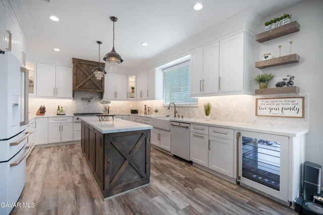 a kitchen with kitchen island granite countertop a sink cabinets and wooden floor