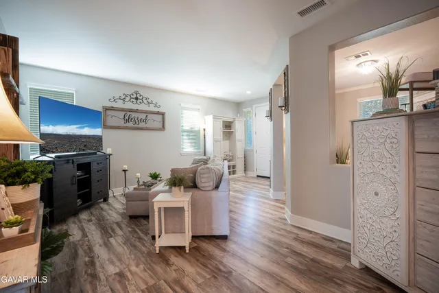 a living room with furniture a table and wooden floor