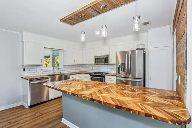 a kitchen with stainless steel appliances granite countertop a sink refrigerator and cabinets