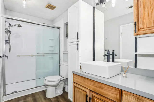 a bathroom with a sink a toilet and shower