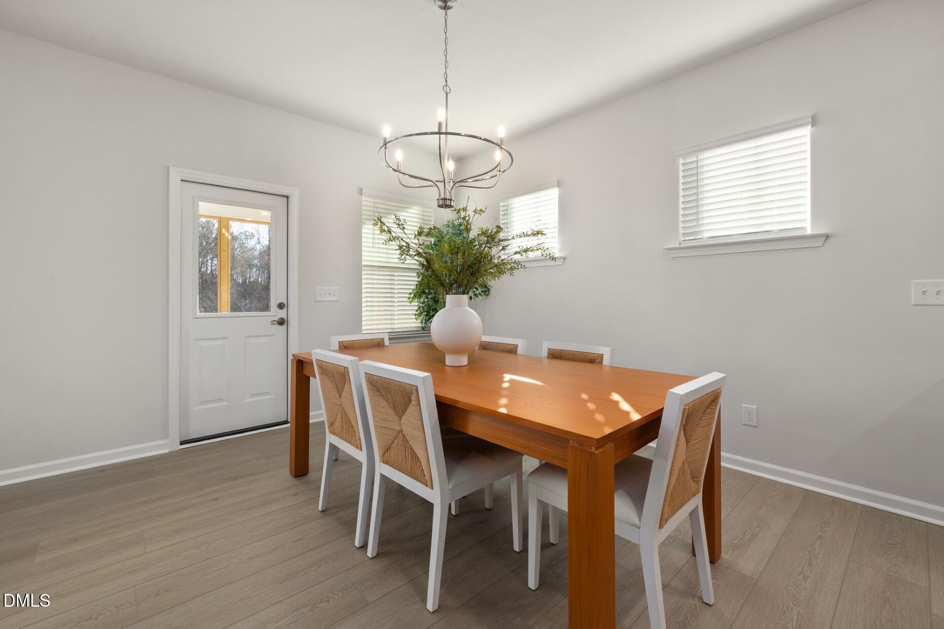 204 Armorial Court Willow Spring, NC 27592 - Photo 6 of 26 a dining room with furniture potted plants and wooden floor