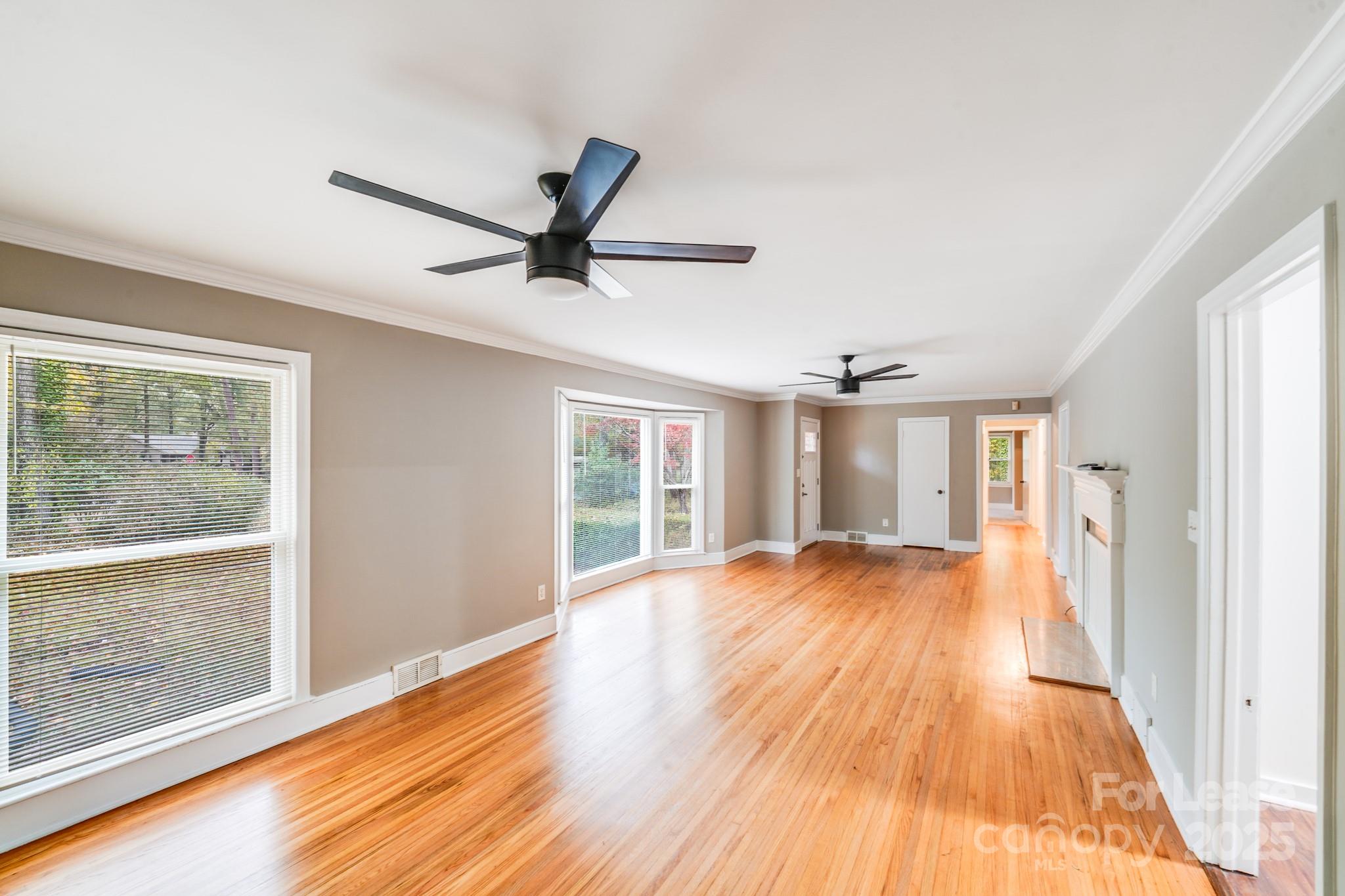 5600 Riviere Drive Charlotte, NC 28211 - Photo 13 of 35 a view of a livingroom with wooden floor and a ceiling fan