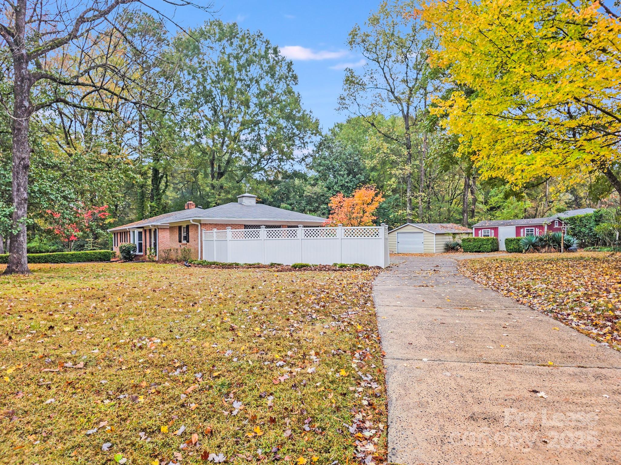5600 Riviere Drive Charlotte, NC 28211 - Photo 31 of 35 a backyard of a house with large trees and plants