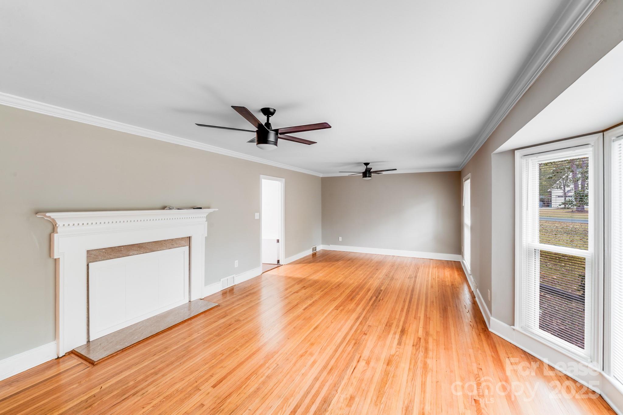 5600 Riviere Drive Charlotte, NC 28211 - Photo 9 of 35 a view of empty room with wooden floor and fan