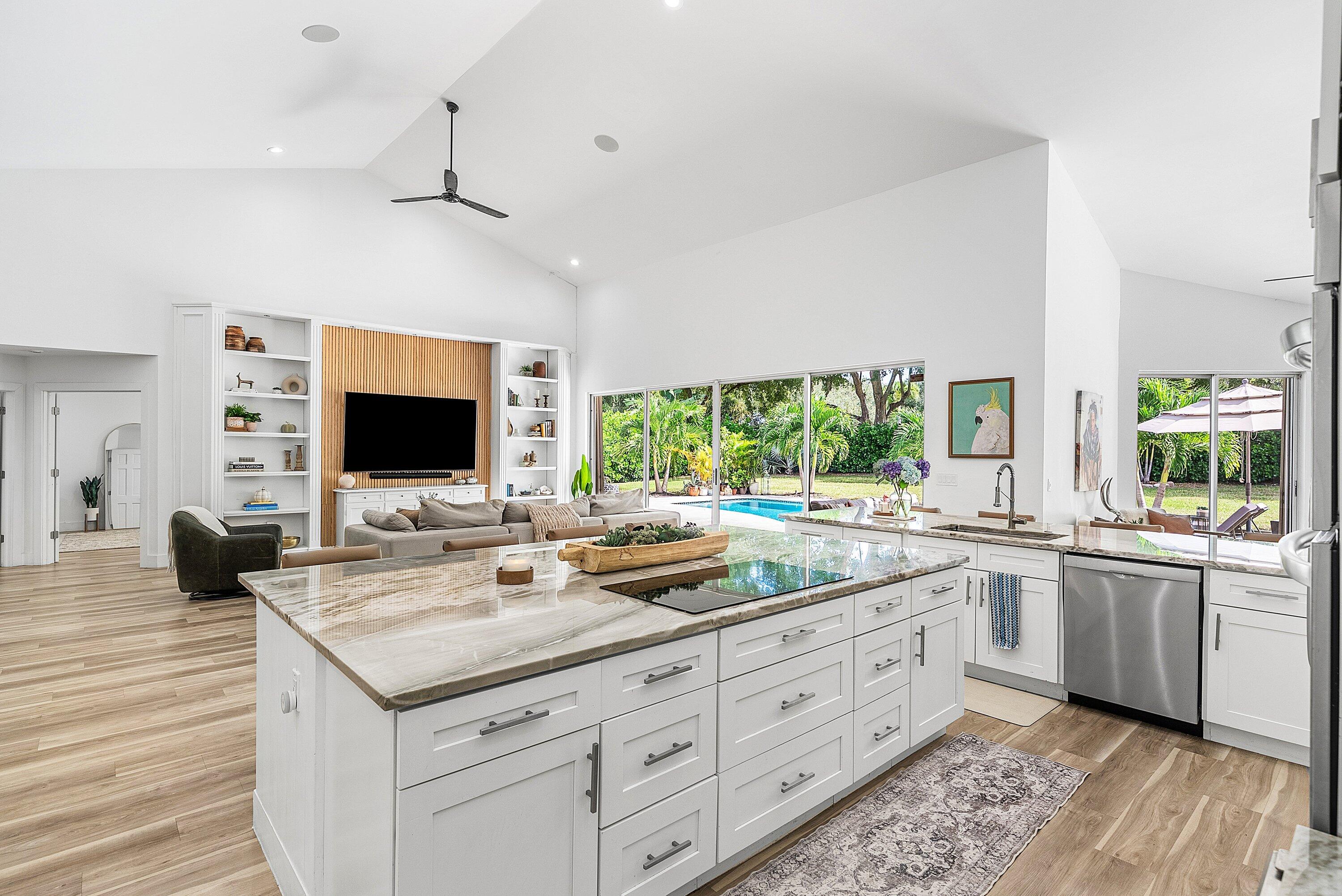 4408 Woodfield Boulevard Boca Raton, FL 33434 - Photo 15 of 53 a open kitchen with stainless steel appliances granite countertop a sink and dishwasher with wooden floor