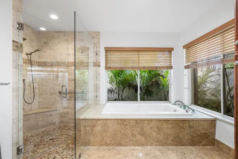 a spacious bathroom with a granite countertop sink mirror and bathtub