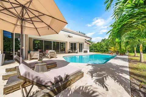a living room with patio furniture and a flat screen tv