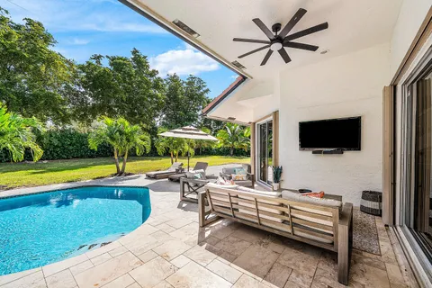 a view of swimming pool with palm trees