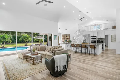 a living room with lots of furniture wooden floor and a rug