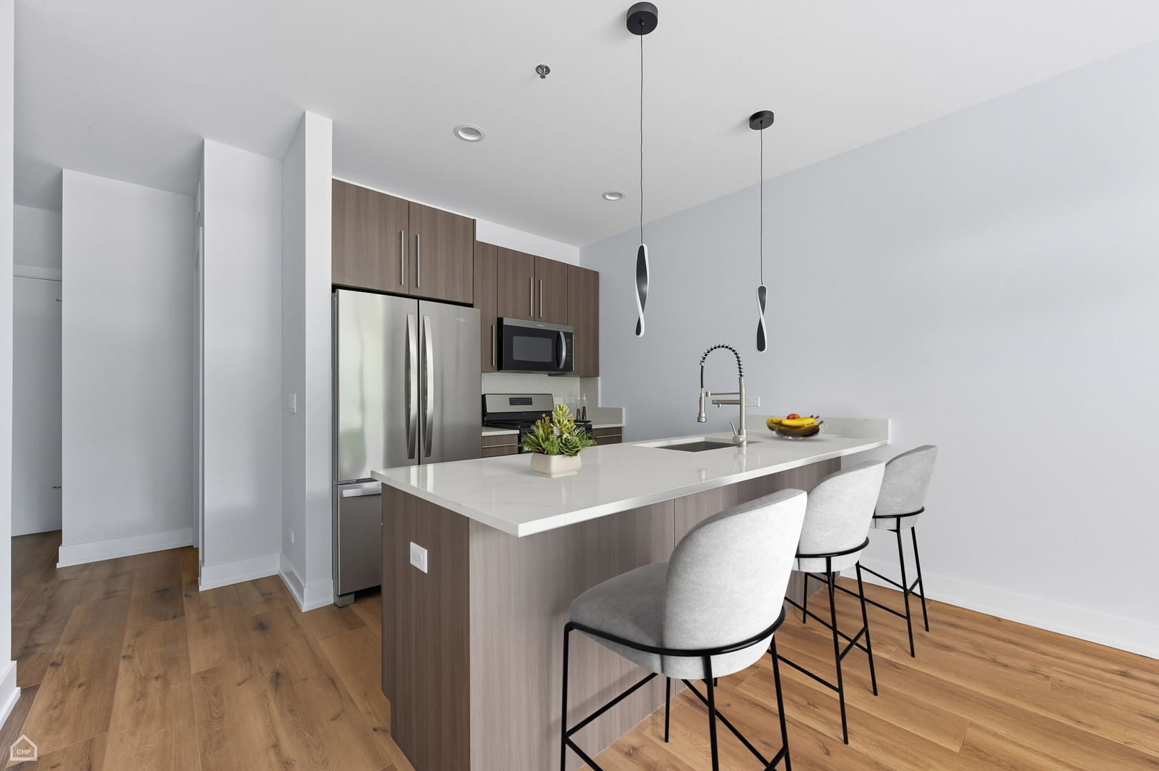 2354 North Washtenaw Avenue, Unit 301 Chicago, IL 60647 - Photo 2 of 16 a kitchen with stainless steel appliances a table chairs and refrigerator