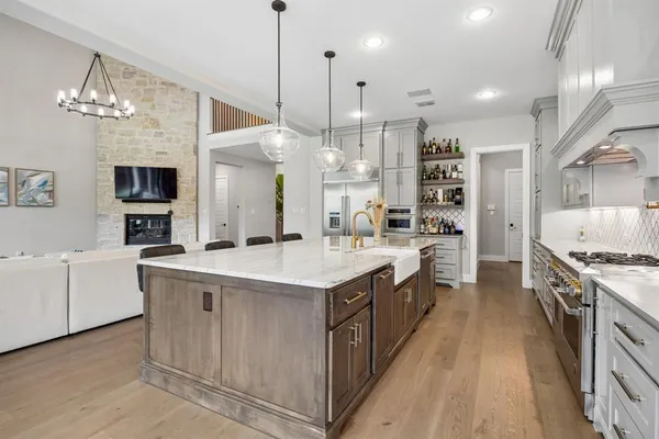 a large kitchen with stainless steel appliances granite countertop a stove and a sink