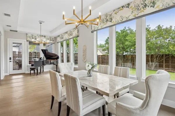 a view of a dining room with furniture large windows and wooden floor
