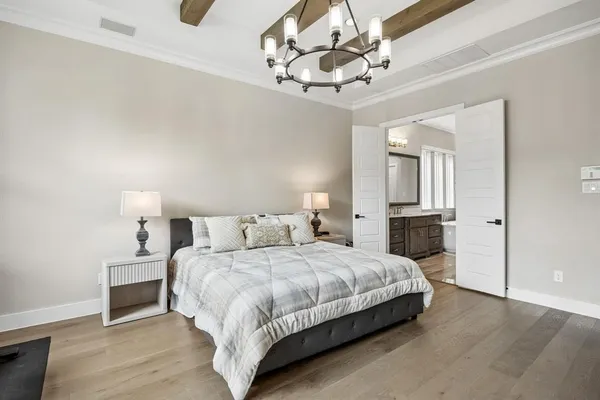 a bedroom with a large bed and a chandelier