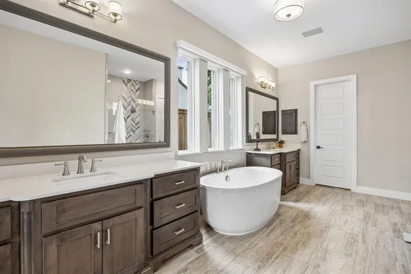 a large bathroom with a granite countertop tub sink and mirror