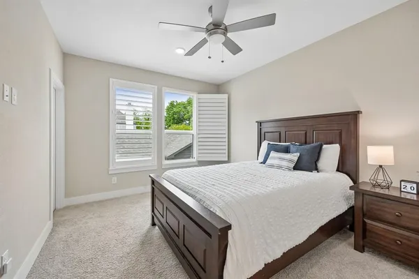 a bedroom with a large bed and a chandelier fan