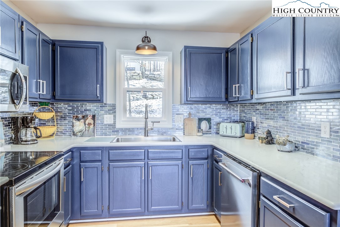523 Pine Ridge Road Beech Mountain, NC 28604 - Photo 11 of 42 a kitchen with stainless steel appliances granite countertop a sink stove and cabinets