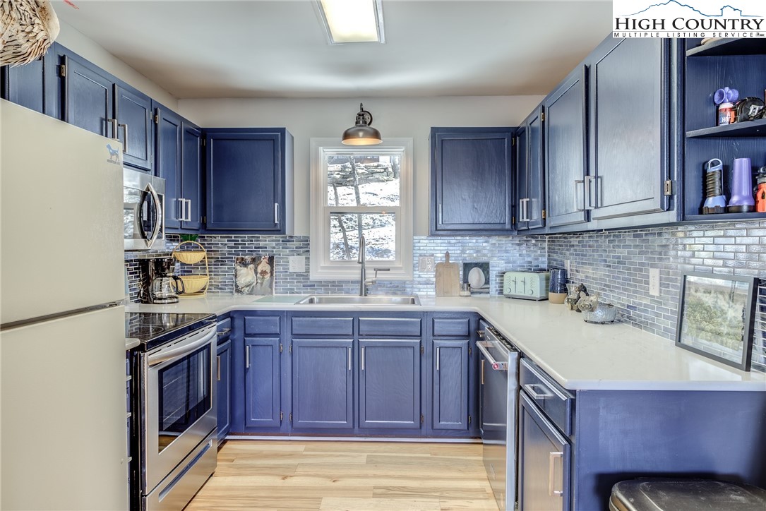 523 Pine Ridge Road Beech Mountain, NC 28604 - Photo 13 of 42 a kitchen with kitchen island granite countertop a sink stove and cabinets