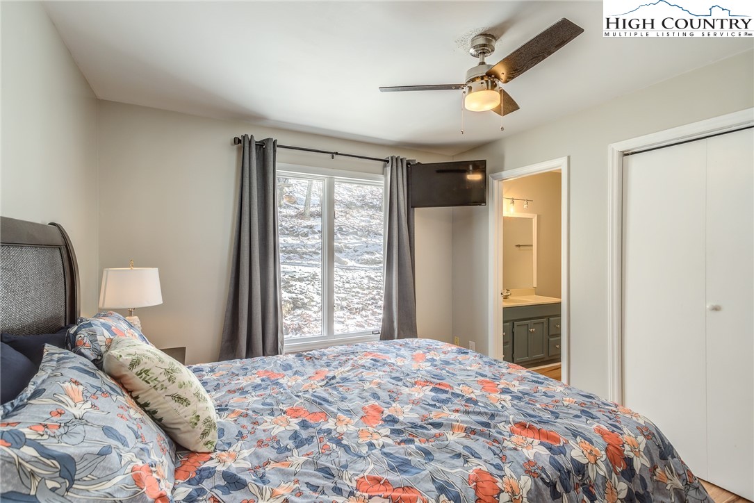 523 Pine Ridge Road Beech Mountain, NC 28604 - Photo 18 of 42 a bedroom with a large bed and a chandelier