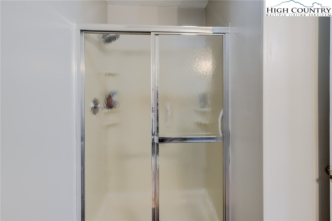 523 Pine Ridge Road Beech Mountain, NC 28604 - Photo 20 of 42 a bathroom with a glass shower door